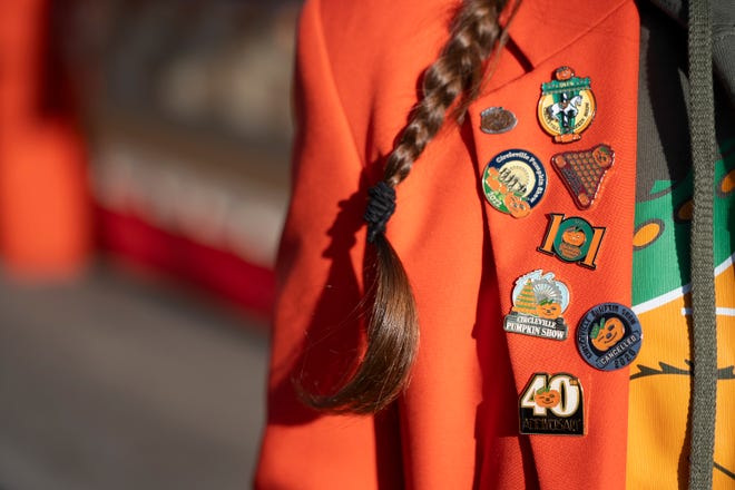 Oct 18, 2023; Circleville, OH, USA; Tiffany Pickett wears an orange blazer displaying pins from years past during the Circleville Pumpkin Show.