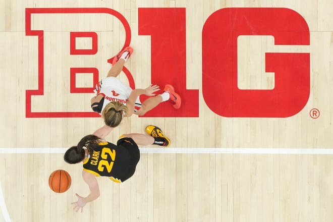Jan 21, 2024; Columbus, Ohio, USA; Iowa Hawkeyes guard Caitlin Clark (22) dribbles over the Big Ten Conference logo while being defended by Ohio State Buckeyes guard Jacy Sheldon (4) during the NCAA women’s basketball game against the Ohio State Buckeyes at Value City Arena. Ohio State won 100-92.