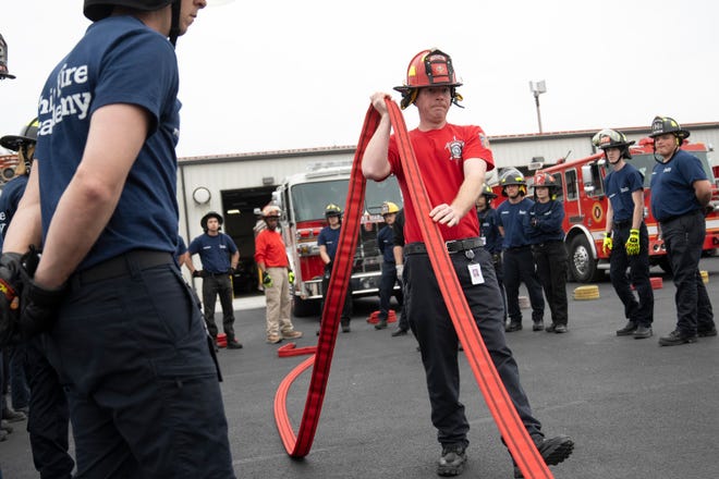 Feb 27, 2024; Reynoldsburg, OH, United States; Instructor Travis Molter demonstrates a technique on how to handle a firehose when gathering it after use during a training session at the Division of State Fire Marshal's Ohio Fire Academy.