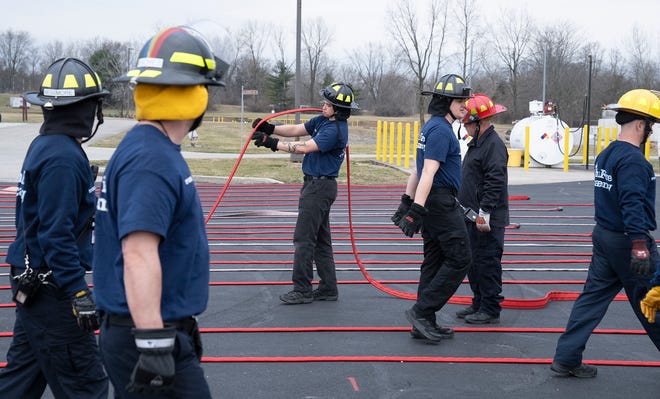 Feb 27, 2024; Reynoldsburg, OH, United States; Matthew Smith holds a firehose during training in a technique on how to handle the hose when gathering it after use during a training session at the Division of State Fire Marshal's Ohio Fire Academy.