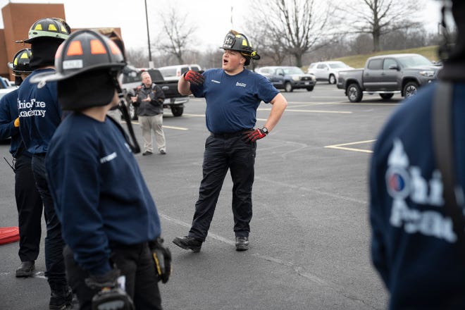 Feb 27, 2024; Reynoldsburg, OH, United States; Jakob Baxter laughs with other students during a training session at the Division of State Fire Marshal's Ohio Fire Academy. Baxter is learning the techniques in order to work as a volunteer firefighter.