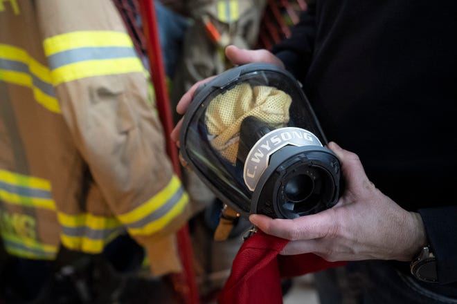Mar 5, 2024; Greenfield, OH, United States; (from left) Fire Chief Chris Wysong holds his mask at the Wayne Township Fire Department in Good Hope, Ohio.