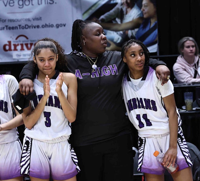 Africentric head coach Janicia Anderson stands with her players Faith Martin (3) and Shaunie Little (11) after beating Ottawa-Glandorf in the OHSAA Division III state championship Saturday, March 16, 2024.