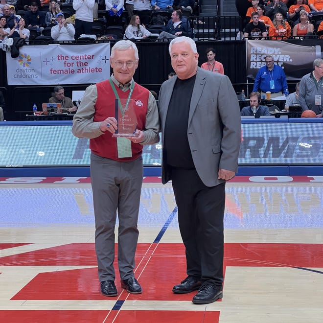 Former Ohio State football coach Jim Tressel poses for a photo with OHSAA executive director Doug Ute after being honored Saturday as part of the OHSAA's Circle of Champions program. The ceremony took place at halftime of the Delaware Hayes-Cleveland St. Ignatius boys basketball state final at University of Dayton Arena.