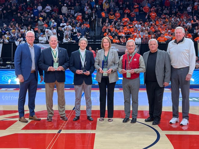 Bob Hoying, Jerry Layne, Dick LeBeau, Caroline Mast Daugherty, Jim Tressel, Doug Ute and Bill Hosket pose for a photo during the OHSAA Circle of Champions ceremony Saturday at the boys basketball state tournament.