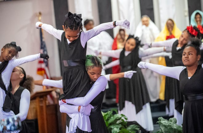 Mar 24, 2024; Columbus, OH; Mariah Lamarr holds up Payton Anderson, 9, as they perform with the Butterflies and OSAO (Our Steps Are Ordered) Dance Ministry during an Easter performance at the Family Missionary Baptist Church on Palm Sunday.
