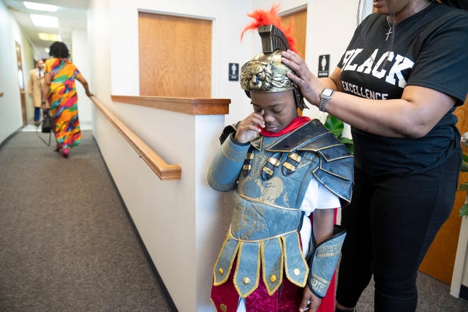 Mar 24, 2024; Columbus, OH; SheÕrod Ingram, 9, dressed as a soldier, wipes away a tear after having his hair braided to fit under his costume helmet an Easter performance at the Family Missionary Baptist Church on Palm Sunday.
