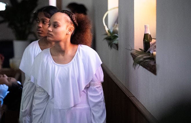 Mar 24, 2024; Columbus, OH; Sion Rone waits behind a pew for her cue to dance with the Butterflies and OSAO (Our Steps Are Ordered) Dance Ministry during an Easter performance at the Family Missionary Baptist Church on Palm Sunday.