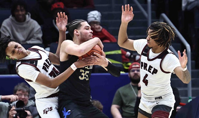 Harvest Prep players Ephraim Campbell (35) and Alan Chiles (4) surround Lutheran East center Jesse McCulloch (35) during the Division III state championship game Sunday, March 24, 2024.