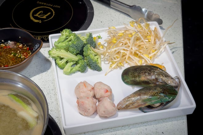 Mar 28, 2024; Columbus, Ohio, USA; A plate of vegetables and seafood is prepared for the hot pot at PJ Hot Pot on the Northwest Side. The restaurant combines two popular Asian dining trends in one restaurant – hot pot and Korean barbecue.
