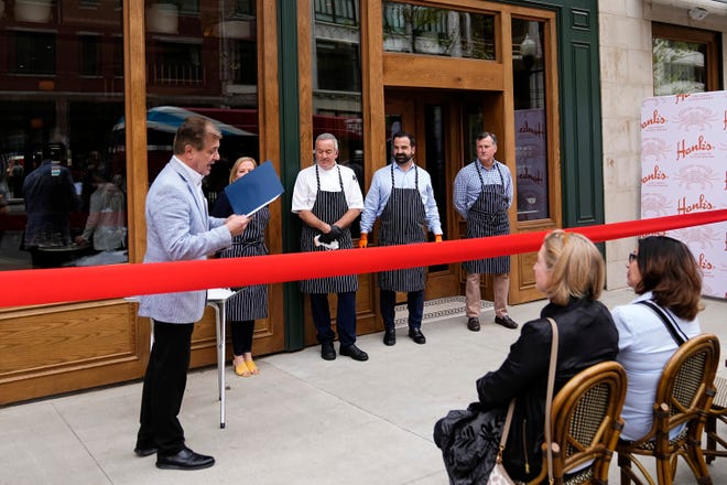 Apr 23, 2024; Columbus, OH, USA; Columbus Chamber of Commerce president Don DePerro reads a proclamation during a the grand opening event for Hank’s Low Country Seafood & Raw Bar at the corner of Gay and High downtown.