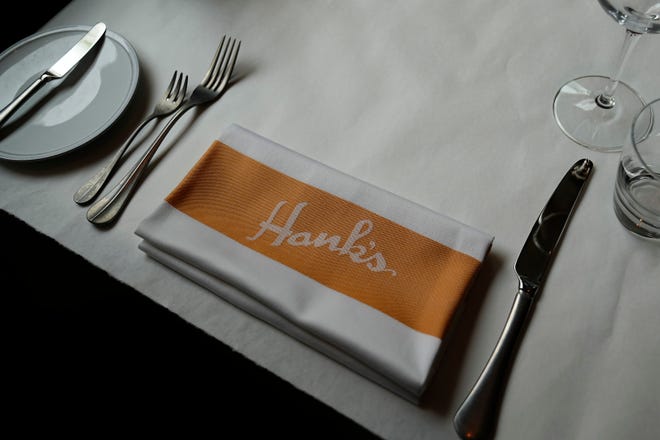 Apr 23, 2024; Columbus, OH, USA; A place setting awaits diners during a the grand opening event for Hank’s Low Country Seafood & Raw Bar at the corner of Gay and High downtown. Hank’s, which opened its first restaurant in Charleston, S.C., includes a lounge, expansive bar, dining room, raw bar and private dining room.