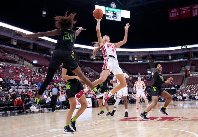 Ohio State Buckeyes guard Jacy Sheldon (4) hangs in the lane as she shoots around Michigan State Spartans guard Nia Clouden (24) during the second quarter of the NCAA women's basketball game at Value City Arena in Columbus on Jan. 12, 2022.